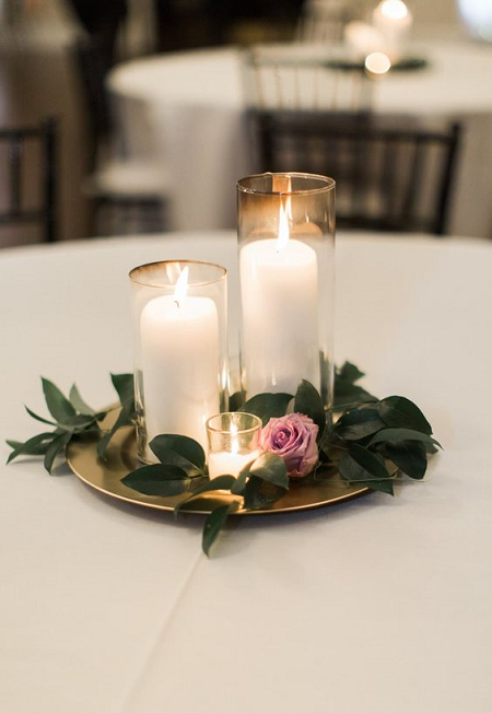 Margarita Campeonato en frente de 15 centros de mesa con velas para tu cena de San Valentín